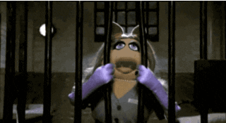 Gif da Miss Piggy, dos muppets, forçando as barras de uma prisão para sair